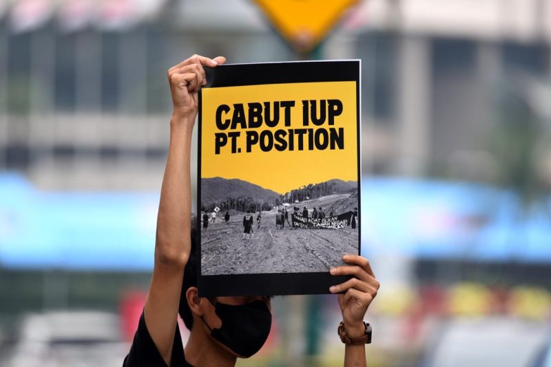 Seorang peserta aksi dengan poster tuntutan pencabutan ijin IUP PT Position. Foto Istimewa