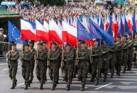 Tentara Polandia berbaris dengan bendera Polandia dan NATO di pusat kota Warsawa pada pertengahan Agustus