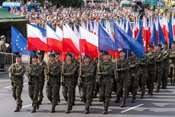 Tentara Polandia berbaris dengan bendera Polandia dan NATO di pusat kota Warsawa pada pertengahan Agustus