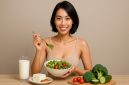 Seorang wanita sedang menikmati makanan sehat berupa salad segar, susu, dan sayuran hijau sebagai bagian dari gaya hidup Diet Lacto-Vegetarian yang menyehatkan tubuh dan menjaga pola makan seimbang.