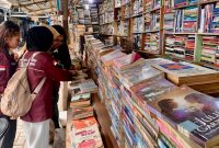 Pengunjung sedang memilih buku di Pasar Buku Medan yang terletak di Jalan Hitam, Kelurahan Perintis, Kecamatan Medan Timur, Kota Medan, Sumatera Utara. Foto: Topikseru.com/Agus Sinaga