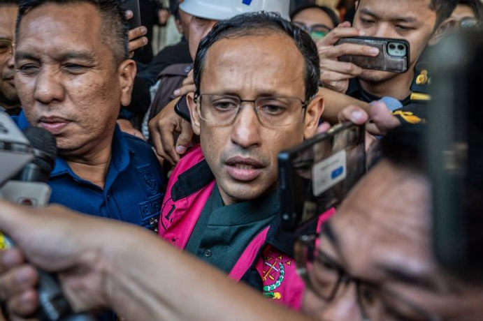 Mantan Menteri Pendidikan, Kebudayaan, Riset, dan Teknologi (Mendikbudristek) Nadiem Makarim (tengah) bersama tim kuasa hukumnya berjalan menuju mobil tahanan usai ditetapkan sebagai tersangka kasus dugaan korupsi dalam pengadaan laptop Chromebook 