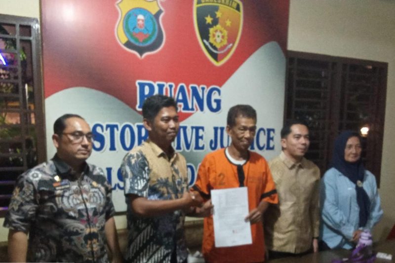Lurah Perintis Muhammad Fadli dan warga Mawardi (61) berjabat tangan dalam pertemuan perdamaian di Polsek Medan Timur. Wali Kota Medan Rico Tri Putra Bayu Waas mendukung penuh penyelesaian kasus ini secara kekeluargaan. Foto : Dok. Pemko Medan