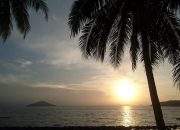 Matahari terbenam di Pulau Lemukutan dengan siluet pohon kelapa dan laut tenang Kalimantan Barat.