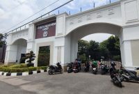 Sejumlah pengemudi ojek online menunggu pesanan di depan Gerbang Utama Universitas Negeri Medan (Unimed), Jalan Willem Iskandar, Kota Medan, Selasa (7/10/2025). Mereka mengeluhkan tidak bisa mengantar penumpang hingga ke fakultas karena adanya pembatasan akses di area kampus. Foto: Topikseru.com/Mangara Wahyudi