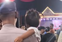Personel Polsek Kota Kisaran, Aipda Hapizul Fitra, menenangkan anak yang sempat hilang di tengah keramaian Pagelaran Seni Budaya Asahan, Senin (13/10/2025).