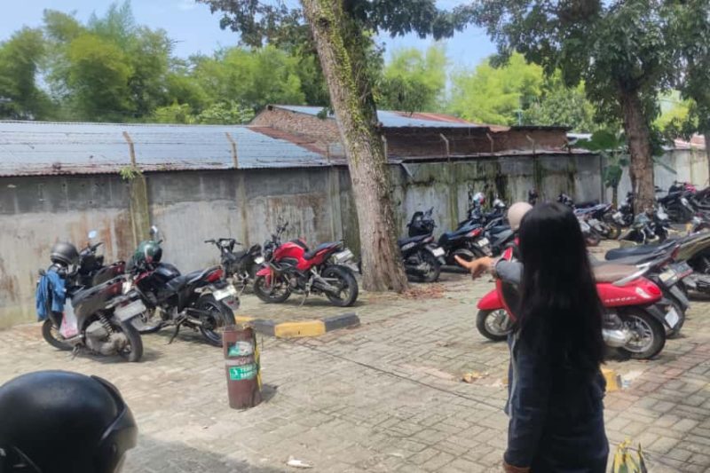 Mahasiswi Universitas Negeri Medan (Unimed) Ana Septiana (20) menunjukkan lokasi tempat sepeda motornya hilang di area Unit Kegiatan Mahasiswa (UKM), Rabu (15/10/2025). Foto: Topikseru.com/Mangara Wahyudi
