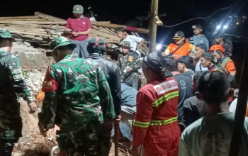 Petugas BPBD dan tim SAR melakukan pencarian korban Longsor Cibeunying di Kecamatan Majenang, Cilacap, pada malam hari dengan medan yang penuh material tanah dan kayu.