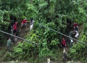 Evakuasi ibu hamil melewati jalan sempit di tebing curam pascabencana alam di Sumatera Barat.