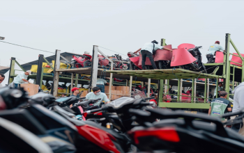 Petugas mengangkut sepeda motor ke truk dalam program Mudik Bareng Honda 2026 sebagai layanan pengiriman motor saat mudik Lebaran.