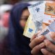 Warga memperlihatkan pecahan uang rupiah baru hasil penukaran tukar uang baru BI Medan 2026 untuk kebutuhan Lebaran.