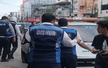 Sejumlah petugas Dishub berdiri di samping mobil pikap putih di pinggir jalan Kota Medan, diduga terkait insiden pungutan liar yang viral di media sosial.