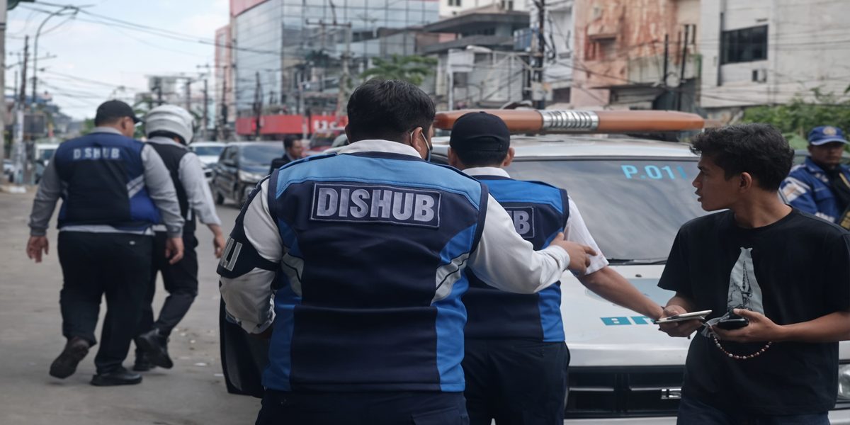 Sejumlah petugas Dishub berdiri di samping mobil pikap putih di pinggir jalan Kota Medan, diduga terkait insiden pungutan liar yang viral di media sosial.
