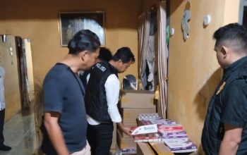 Polisi memeriksa tumpukan kardus berisi rokok ilegal di dalam rumah yang digerebek di Padang Lawas, Sumatera Utara