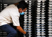 Ilustrasi petugas menyusun wadah makanan (food tray) untuk Program Makan Bergizi Gratis (MBG) yang menjadi bagian dari penyidikan dugaan korupsi oleh Kejaksaan Agung.